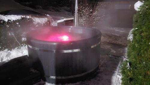 um barril grande com uma luz vermelha na neve em Zielony Zakątek koło Karpacza em Sosnówka