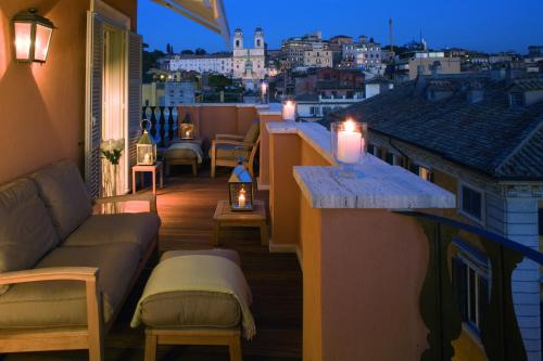 a balcony with a couch and a view of the city at Portrait Roma - Lungarno Collection in Rome