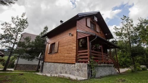 a small wooden cabin on a grass field at Guest House Rustico in Korenica