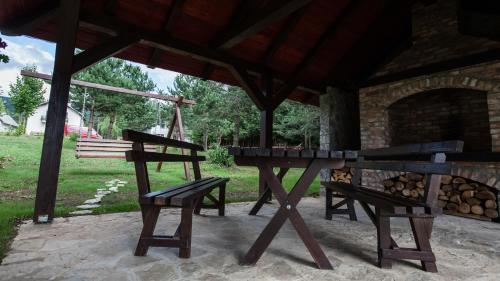 a picnic table and a bench under a pavilion at Guest House Rustico in Korenica