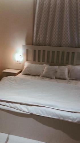 a bed with white sheets and pillows in a bedroom at Altaraf Resort in Al Shafa