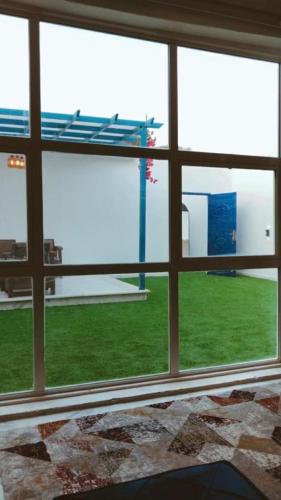 a room with a window with a view of a field at Altaraf Resort in Al Shafa