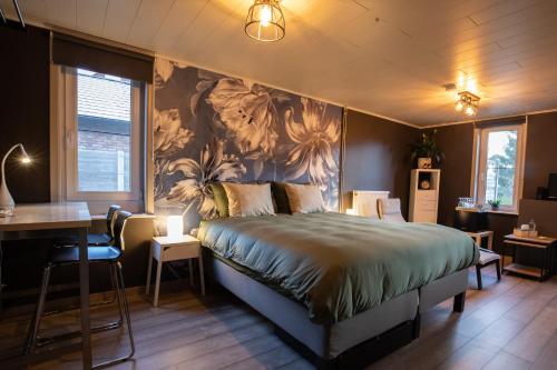 una camera da letto con un letto, un tavolo e una scrivania di B&B De Oude Berg a Mol