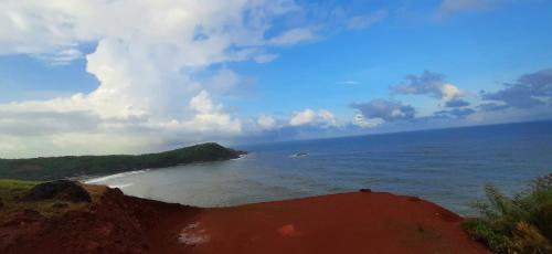 a view of the ocean from a cliff with a beach at Niramaya beach view stay in Gokarna