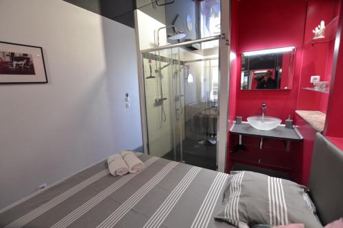 - une salle de bains rouge avec un lit et un lavabo dans l'établissement Studio Naturiste 