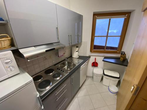 cocina con fregadero y fogones horno superior en Appartement Gafluna en Sankt Anton am Arlberg