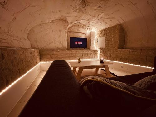a living room with a couch and a tv in a cave at La Cave aux Lumières in Renaison