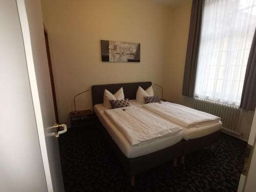 a bedroom with a bed and a window at Badhotel Bad Brückenau in Staatsbad Brückenau