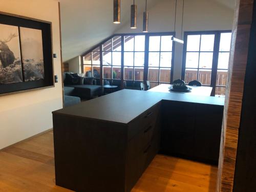 a kitchen with a black island in a living room at Appartements Innerkofler Mountain Home in San Candido