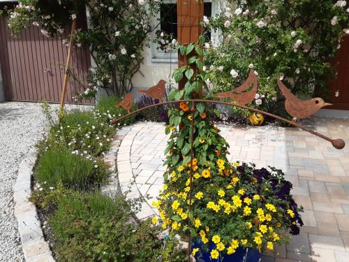 a garden with a bunch of flowers and chickens at Landpension Heidi Machold in Weißenstadt