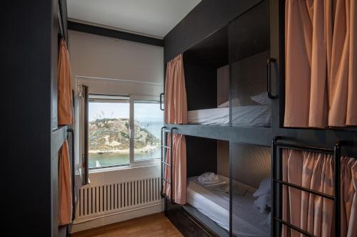 pokój z dwoma łóżkami piętrowymi i oknem w obiekcie BEDWAVE Seaside Mansion w Pireusie