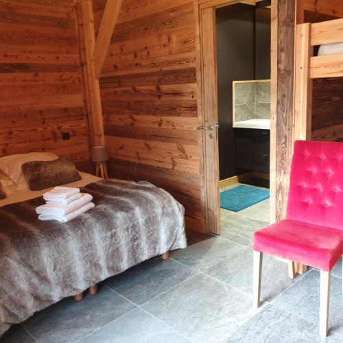 une chambre avec un lit et une chaise rouge dans l'établissement CHALET MARY, à Essert-Romand