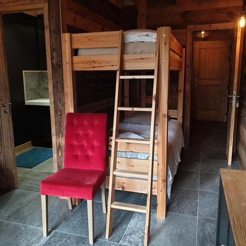 Essert-RomandにあるCHALET MARYの二段ベッド2台と赤い椅子が備わる客室です。