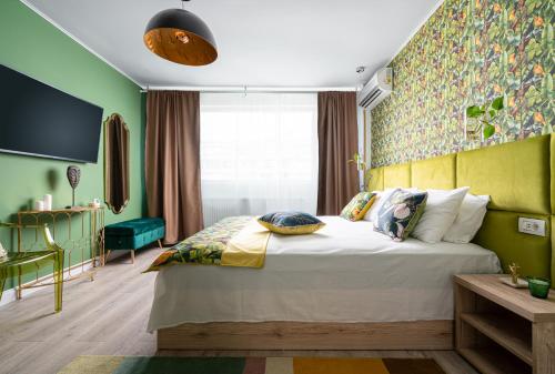 um quarto com uma cama e uma parede verde em Amazon - DeLuxe One Bedroom em Bucareste