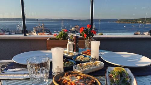 a table with plates of food on it with a view of the water at Kule Hotel in Canakkale