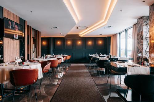 a restaurant with tables and chairs in a room at Palace Hotel & SPA in Mitrovicë