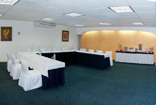 a conference room with white tables and white chairs at Hotel & Suites PF in Mexico City