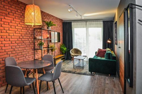 a living room with a green couch and a brick wall at Apartament LOFTSPA in Ustrzyki Dolne