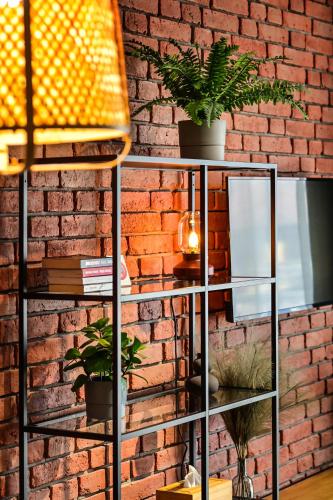 a metal shelf with plants on a brick wall at Apartament LOFTSPA in Ustrzyki Dolne