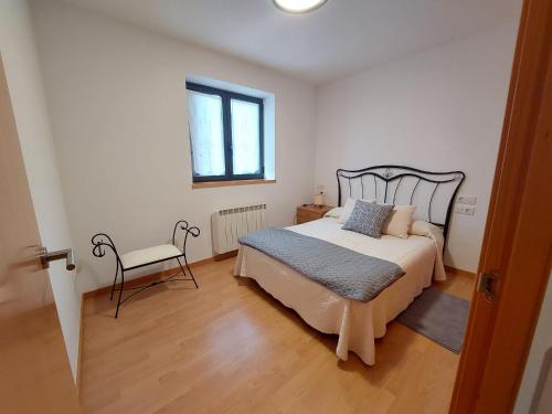 1 dormitorio con 1 cama y 1 silla en Dúplex València d'Àneu, en Valencia de Aneu