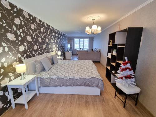 Un dormitorio con una cama y un árbol de Navidad en él en Kraslava 2 Bedroom Lux Apartments, en Krāslava