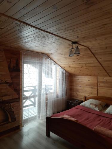 1 dormitorio con cama y ventana grande en Guest House Stari Druzy en Slavske
