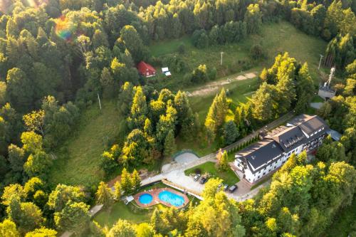 eine Luftansicht eines Anwesens mit Zug und Pool in der Unterkunft Dom Wczasowy SZCZYT in Muszyna