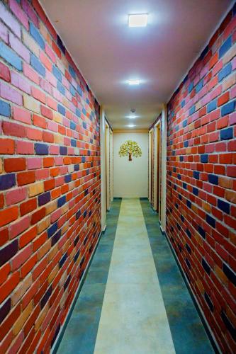 a corridor of a building with a brick wall at Laughing Waters Fine Stay in Kuttālam
