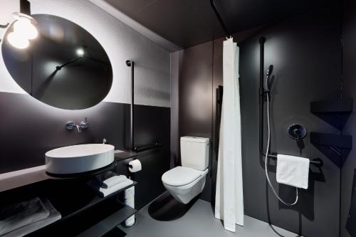 a bathroom with a toilet and a sink and a shower at Apart Hotel Adelboden am Dorfplatz in Adelboden