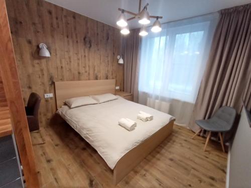 a bedroom with a bed and a chair and a window at CozyStudio in Obninsk