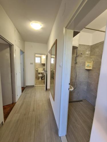 a hallway of a bathroom with a shower and a sink at APARTMENT IVANA in Brodarica