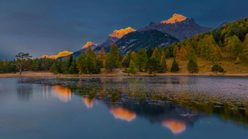 a view of a lake with mountains in the background at Familiehotel La Randulina in Ramosch