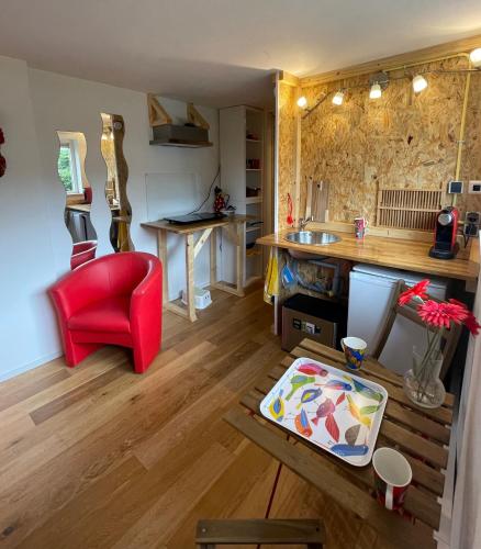 a kitchen with a red chair and a table at Studio 7 in Hoogland