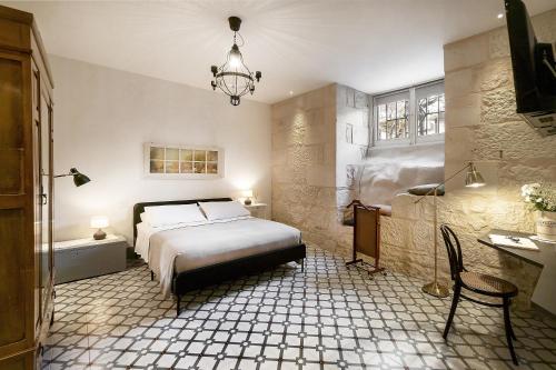 a bedroom with a bed and a chandelier at I CARIZZI in Ragusa