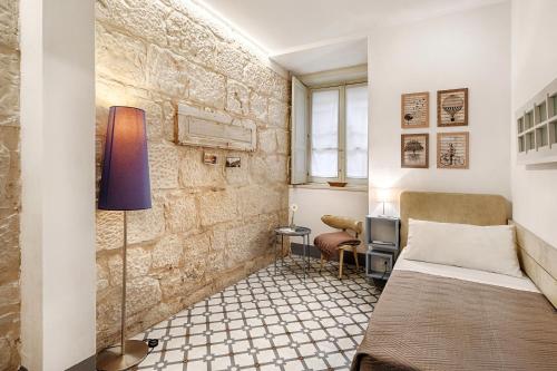a small room with a bed and a desk at I CARIZZI in Ragusa