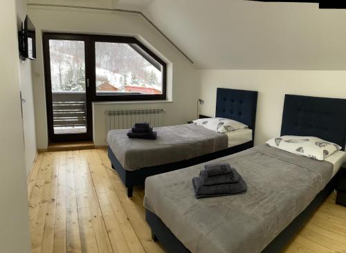 Dos camas en una habitación con ventana y una ventana. en Salmopolskie Zacisze, en Szczyrk