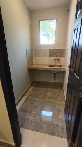 a bathroom with a sink and a window at Godwill Kimo Guest house Seraulim in Madgaon