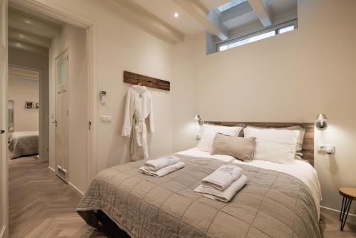 1 dormitorio con 1 cama grande y 2 toallas. en Leidse Square 5 star Luxury Apartment en Ámsterdam