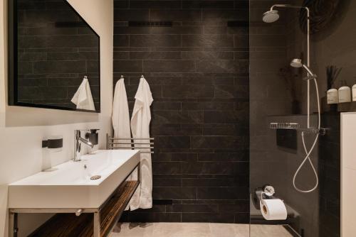 une salle de bain avec un lavabo blanc et une douche dans l'établissement Leidse Square 5 star Luxury Apartment, à Amsterdam