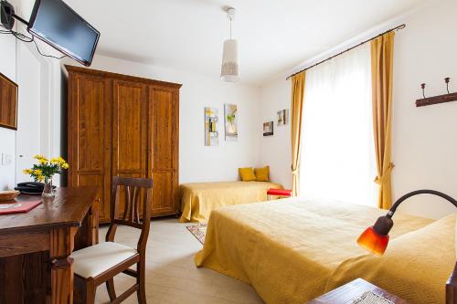 a hotel room with two beds and a desk and a desk at Osteria da Cesare e Locanda in Castel San Pietro Terme