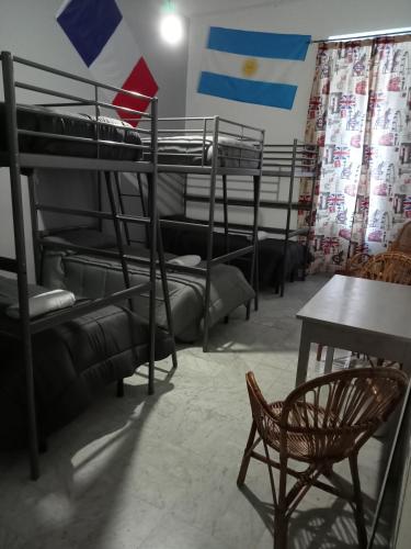 a room with bunk beds with a table and a chair at Dama HostelBB in Naples