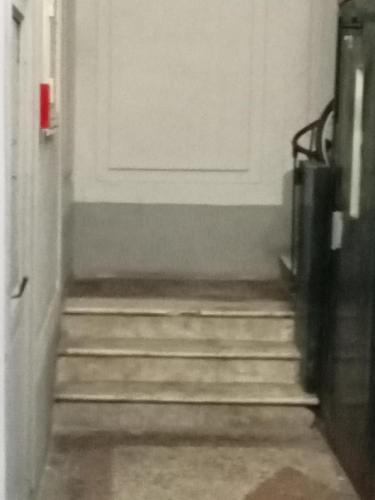a hallway with stairs leading to a white door at Dama HostelBB in Naples