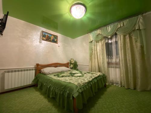 a bedroom with a bed and a green ceiling at Plavianska Sadyba in Plav'ya