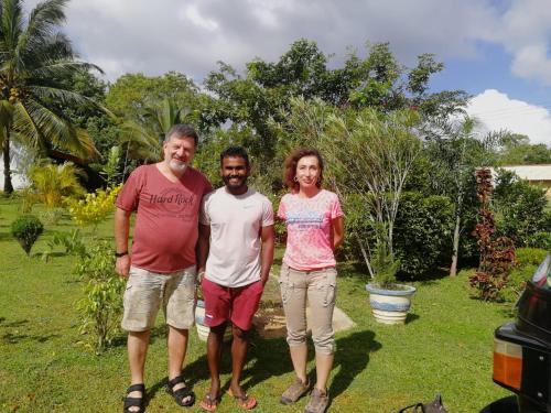 a group of three people standing in a yard at Nice View Lodge in Sigiriya