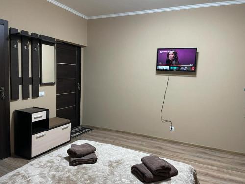 - une chambre avec un lit et une télévision murale dans l'établissement Капрі, à Moukatcheve