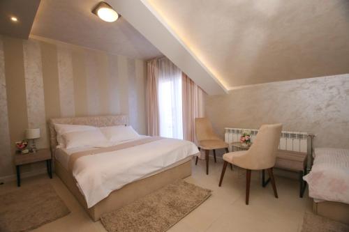 Schlafzimmer mit einem Bett, einem Tisch und Stühlen in der Unterkunft Bajadera Lux in Belgrad