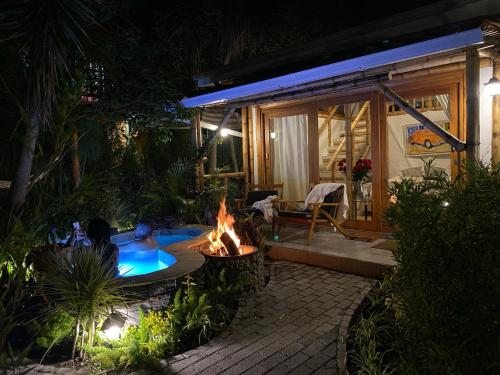 a backyard with a hot tub and a fire pit at night at Hostería Colibri Aeropuerto in Tababela
