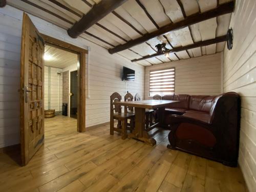 a dining room with a table and leather chairs at Plavianska Sadyba in Plav'ya