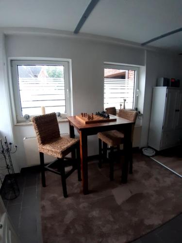een kamer met een schaakbord op een tafel en 2 stoelen bij Westwind in Eggstedt