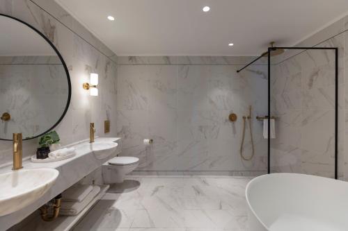 y baño con 2 lavabos, aseo y espejo. en Galei Kinneret Hotel en Tiberias